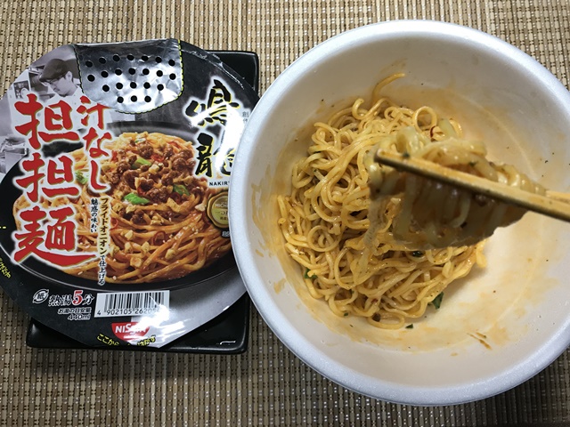 セブンプレミアム：鳴龍(NAKIRYU)　汁なし担担麺を箸でつまんだところ